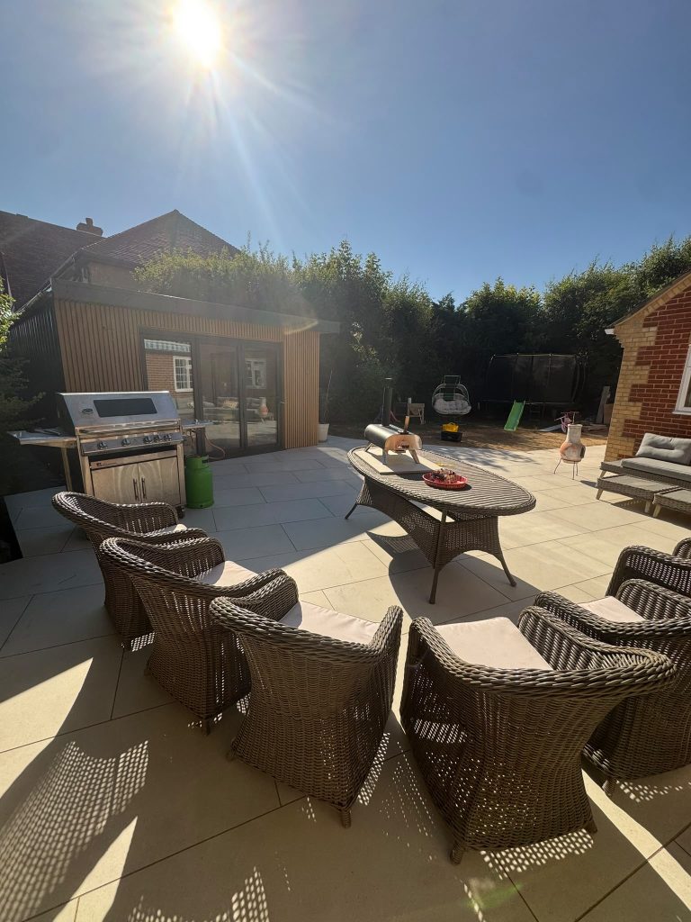 backyard with garden chairs facing a garden table under a soft sun