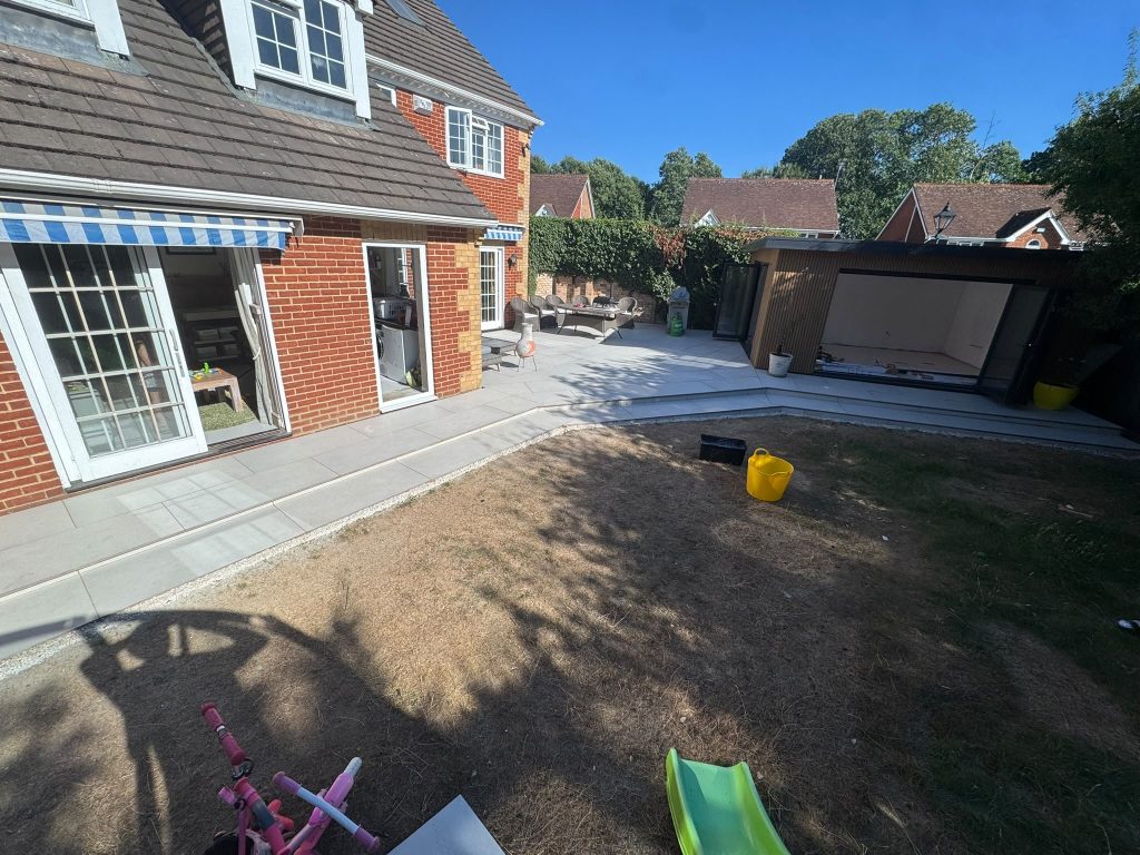 A backyard under construction with a red brick house and dirt on the ground